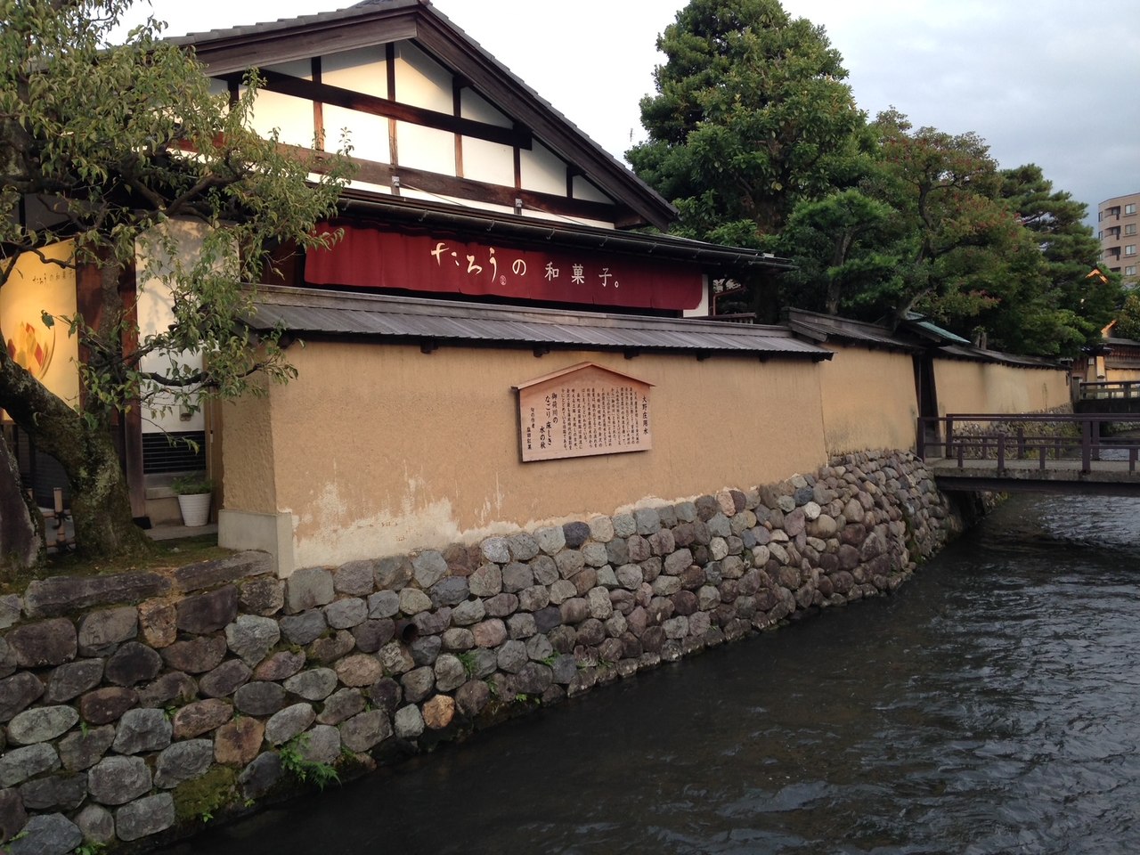 Un bâtiment traditionnel au-dessus d'une berge en pierre, à Kanazawa