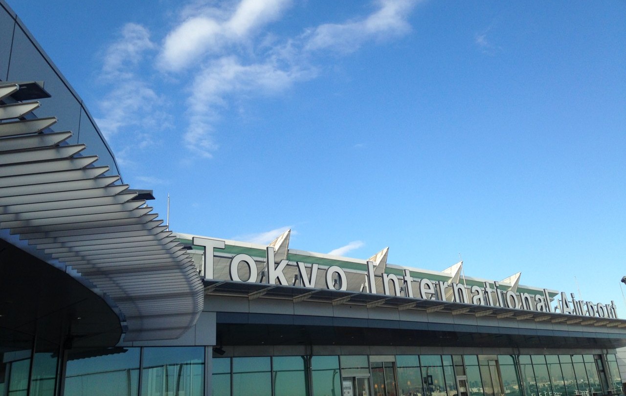 Panneau Tokyo International Airport sur le toit du terminal de l’aéroport de Haneda sous un ciel bleu