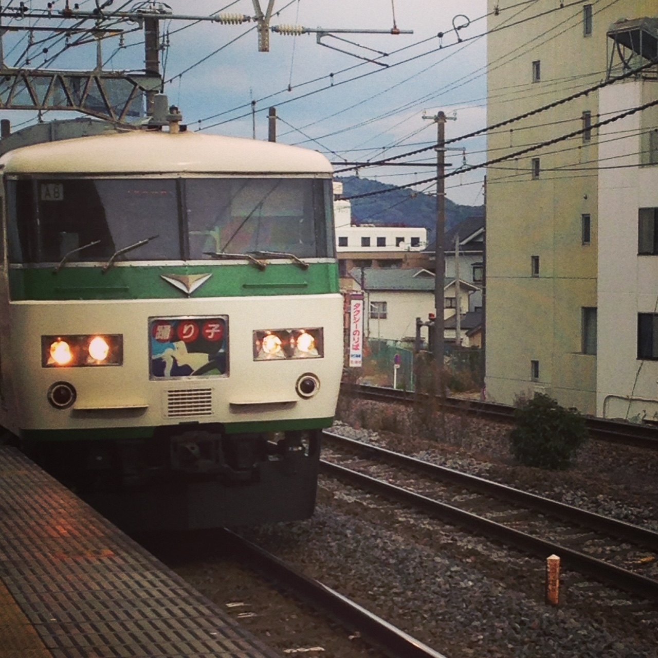 The Odoriko limited express at a station, its headboard showing the train name